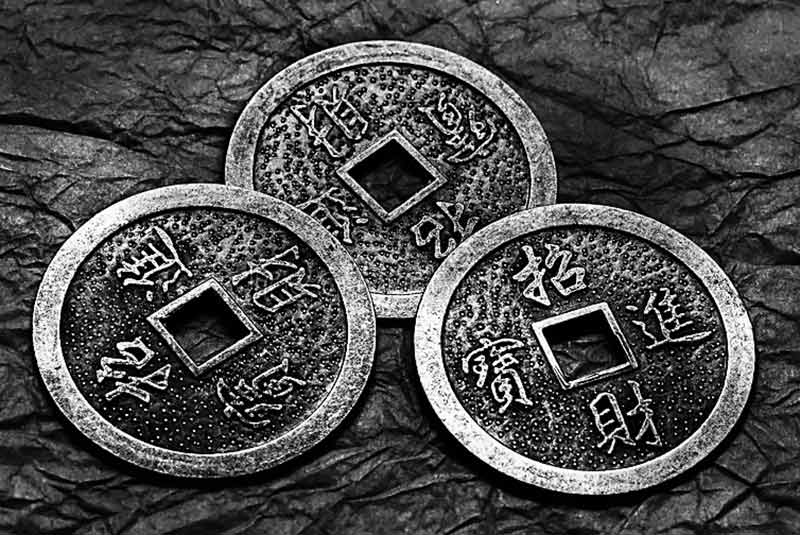 Le monete con cui si consulta l'I Ching. La moneta cinese tradizionale ha un foro quadrato al centro che rappresenta la terra, mentre la loro forma circolare rappresenta il cielo. In realtà all'origine del foro vi è un motivo pratico: le monete venivano legate alla cintura con un laccio, in modo da essere facilmente trasportabili.