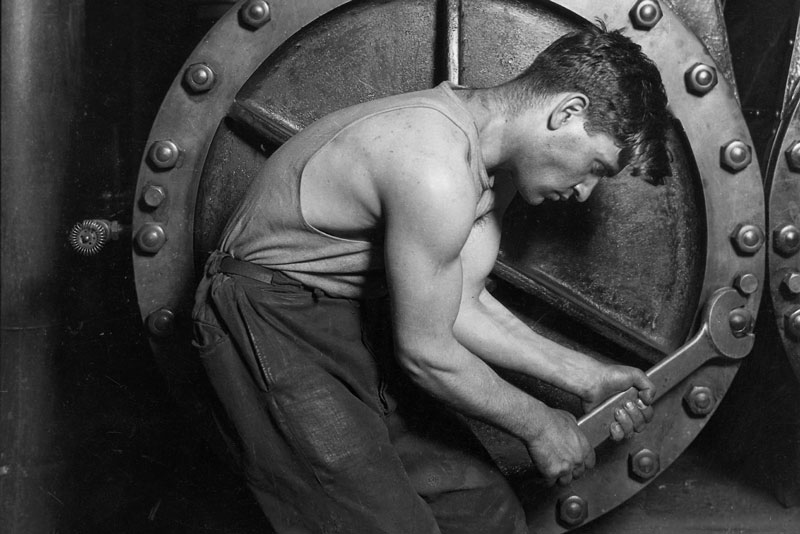 Lewis Hine, Power house mechanic working on steam pump, 1920